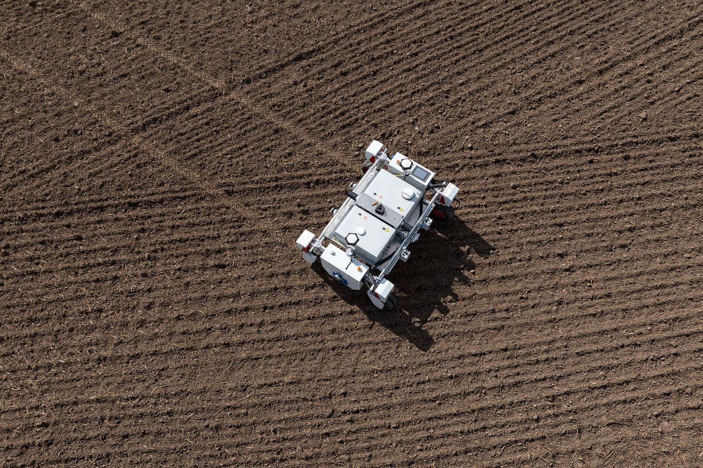 Autonomer Roboter fährt über Acker, aufgenommen aus Vogelperspektive